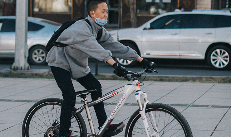 A photo of a Mongolian student on a bike. 