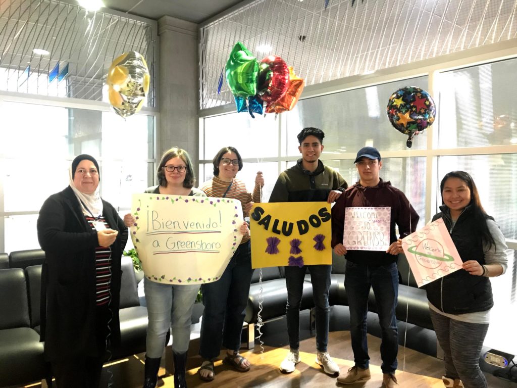 A photograph of Guilford students and resettlement agency staff welcoming guests at an airport.